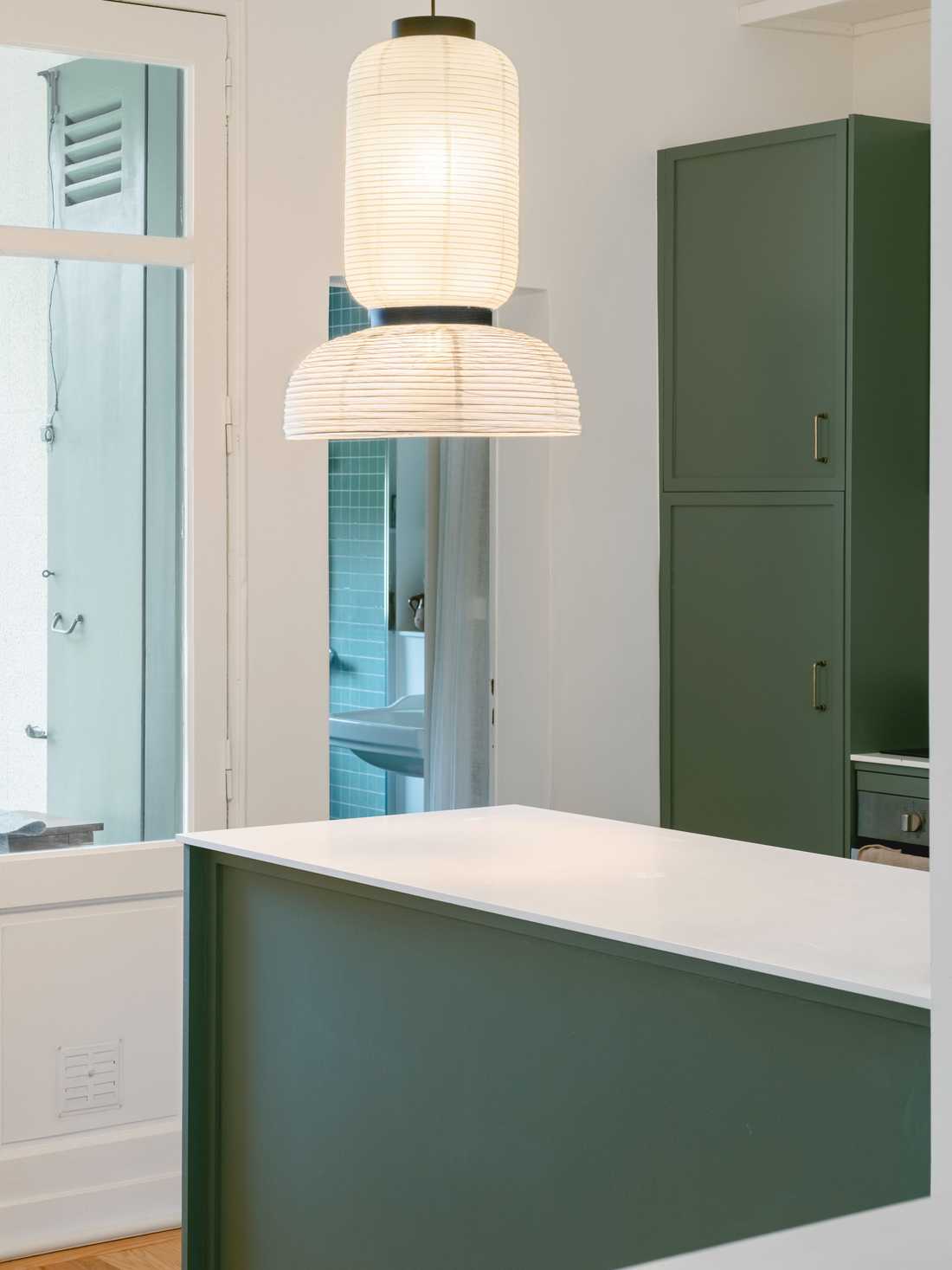 Cuisine contemporaine avec caisson vert et plan de travail blanc